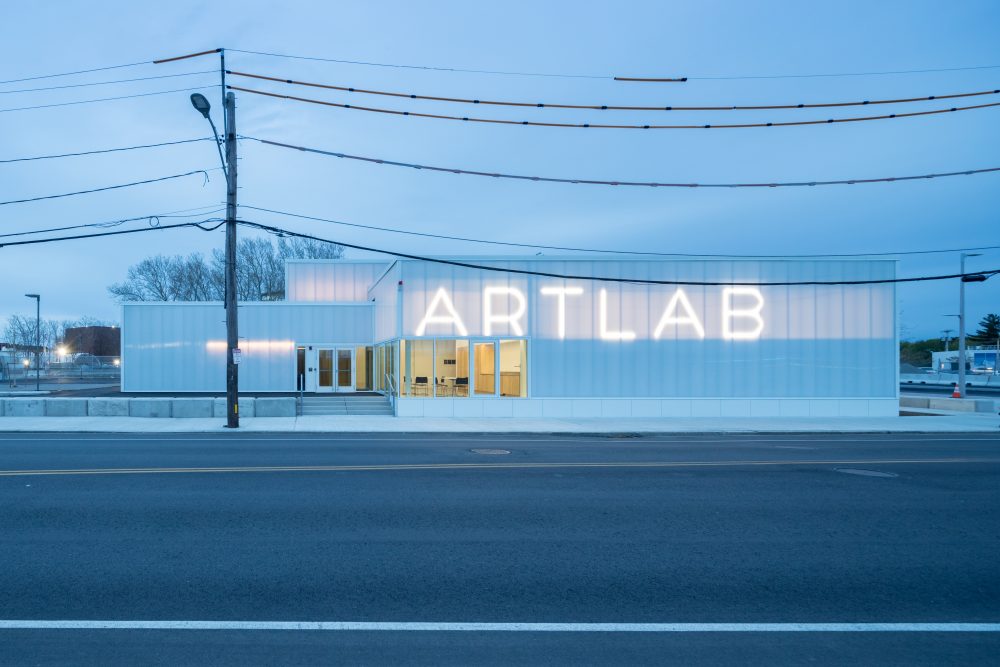A white building with large lit letters reading ARTLAB.