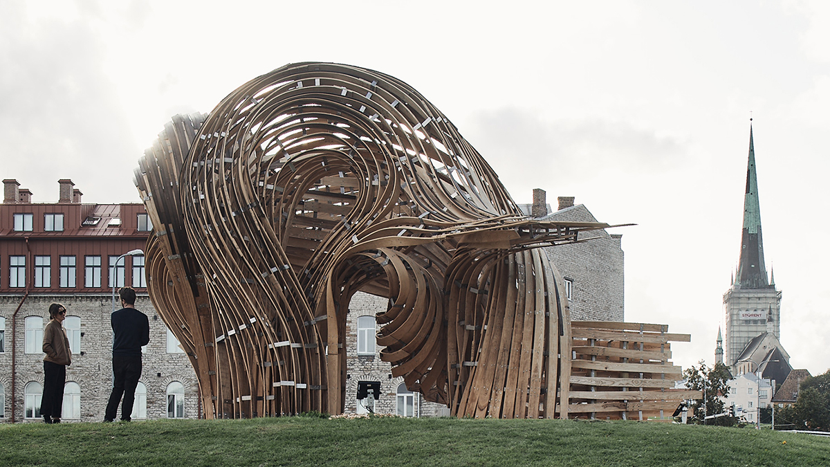 A large curbed wooden structure made of interwoven planks.