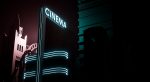 A glowing neon sign that reads CINEMA
