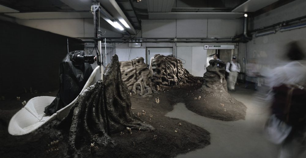 A cellar-like room is filled with printed piles of soil.