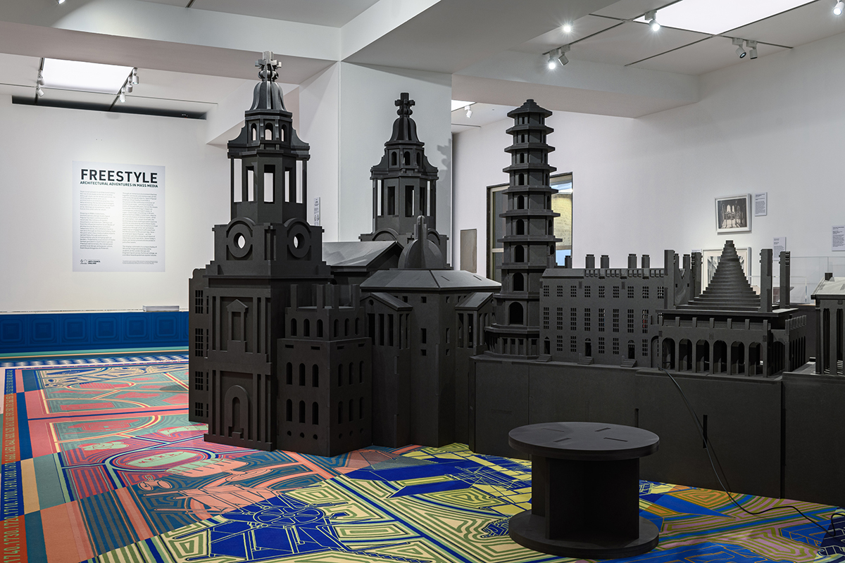 A large black architectural model on a colorful carpet