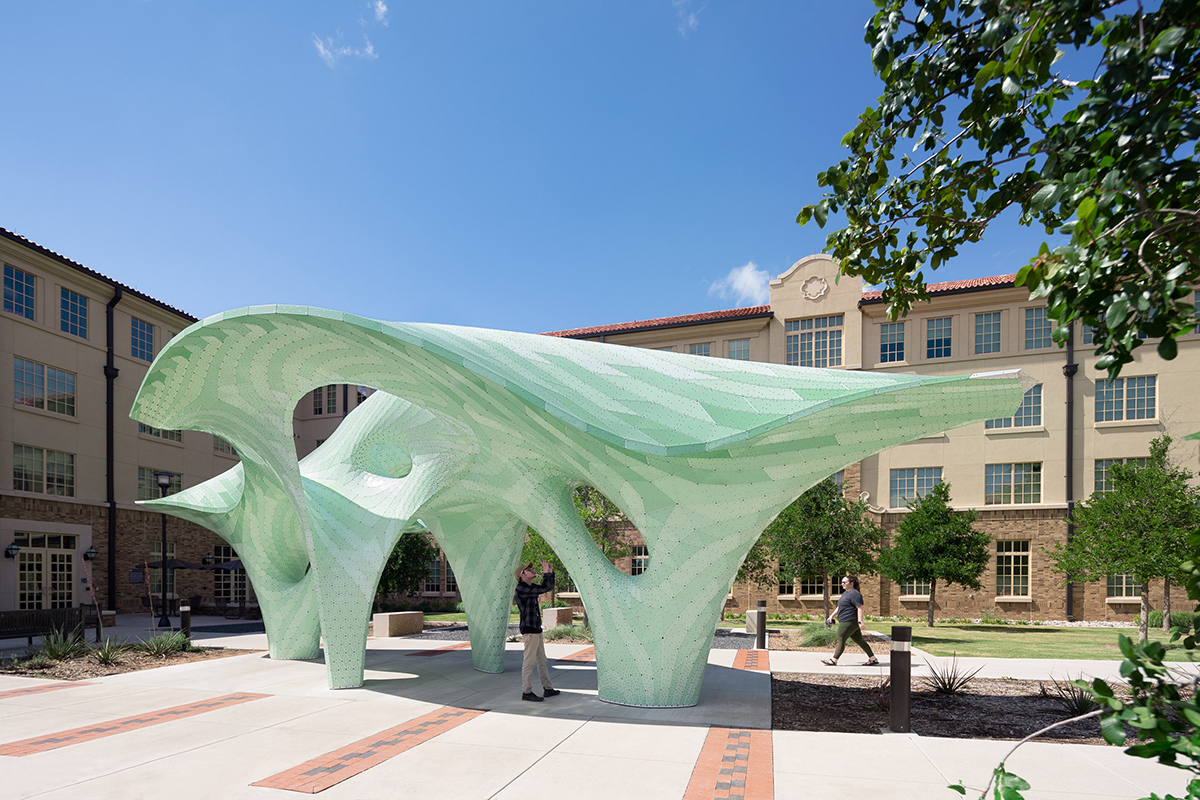 An undulating green pavilion in a public square at a university, designed by Marc Fornes / THEVERYMANY