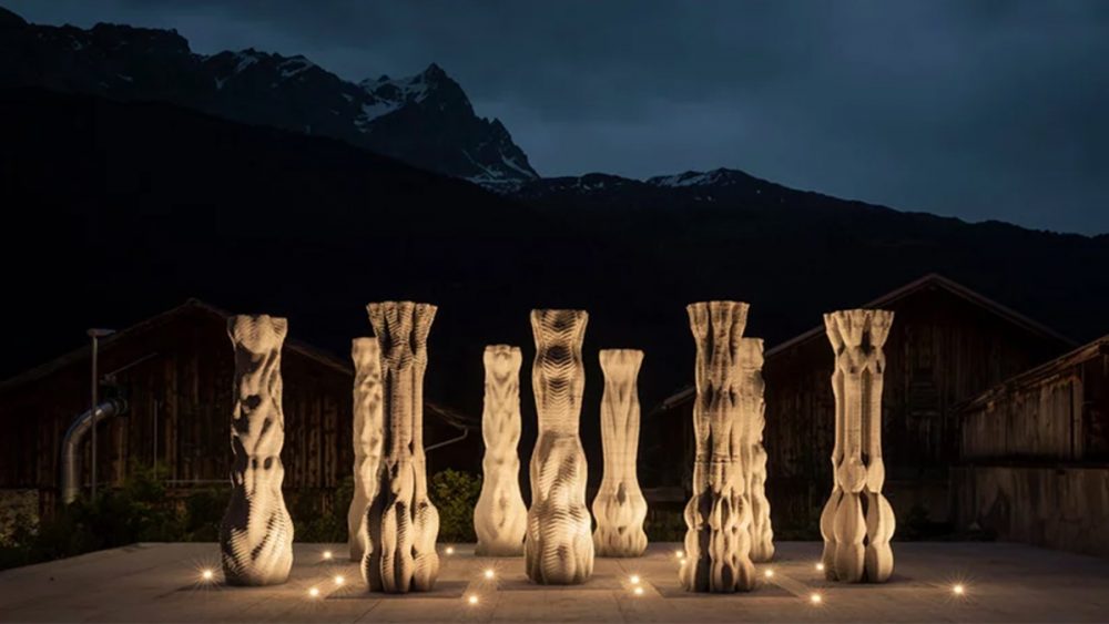 Nine concrete columns are lit below in front of a mountain in a nighttime scene thanks to the team from ETH Zurich